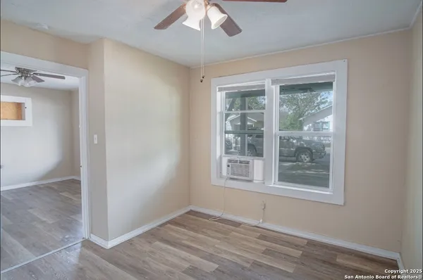 an empty room with a window and wooden floor