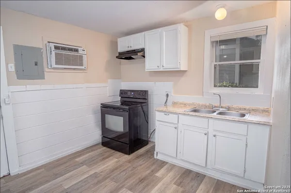 a kitchen with granite countertop white cabinets and sink