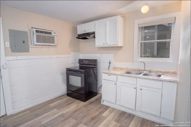a kitchen with granite countertop white cabinets and sink