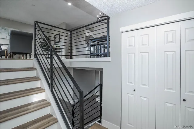 a view of staircase with lots of frames on wall and a window