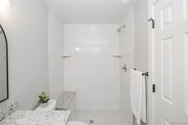 a bathroom with a granite countertop sink a toilet and a mirror