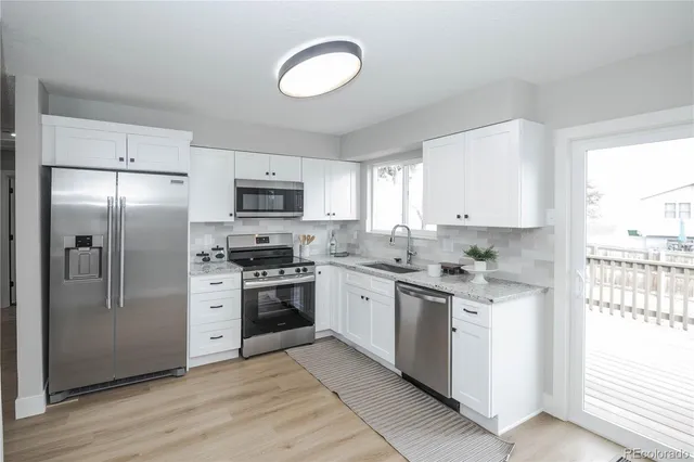 a kitchen with stainless steel appliances granite countertop a stove a sink and a refrigerator