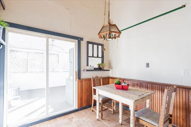 a room with a window a dining table and chairs