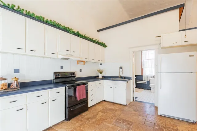 a kitchen with granite countertop a sink a stove and cabinets