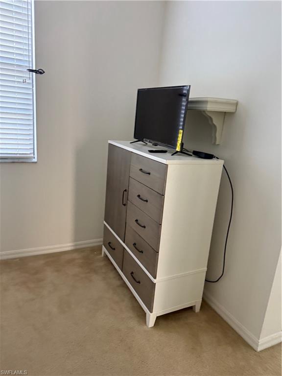 15155 Summit Pl Circle, Unit 232 Naples, FL 34119 - Photo 11 of 27 a living room with furniture and a flat screen tv