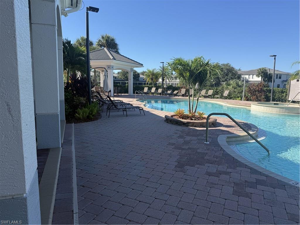 15155 Summit Pl Circle, Unit 232 Naples, FL 34119 - Photo 2 of 27 a swimming pool with outdoor seating and yard