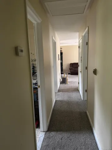 a view of a hallway with a livingroom and a bathroom with sink