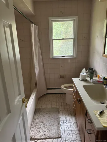 a bathroom with a sink toilet and window