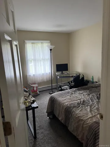 a bed sitting in a spacious bedroom next to a window