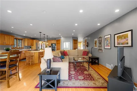 a living room with lots of furniture and a view of kitchen