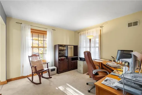 a view of a workspace with furniture and a window