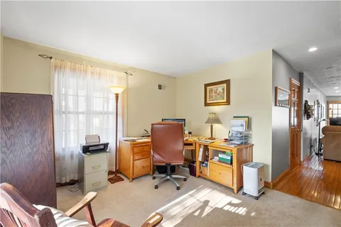 a view of a workspace with furniture and a window