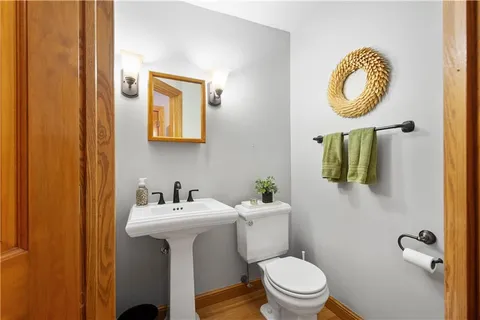 a bathroom with a toilet a sink and mirror