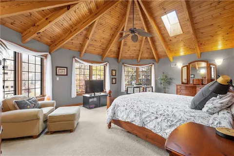 a bedroom with a bed couch and a large window