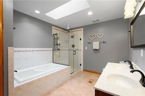 a spacious bathroom with a tub shower and mirror