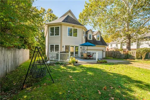 a view of a yard with an tree and wooden fence
