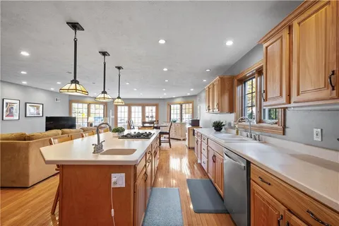 a large kitchen with kitchen island a sink a counter space appliances and a window