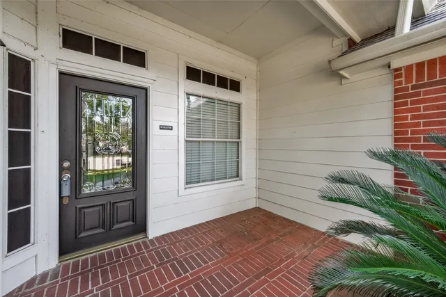 a view of a livingroom with wooden floor a ceiling fan and windows