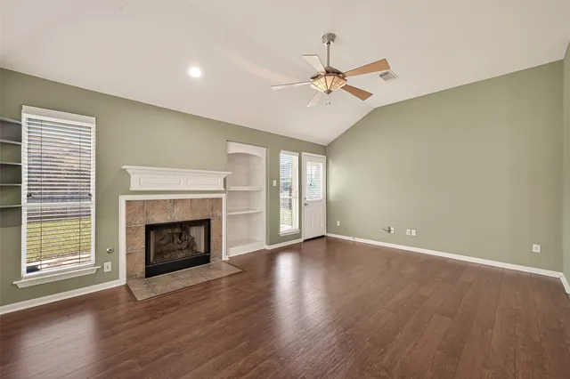 a kitchen with granite countertop a stove a sink and a refrigerator with wooden floors