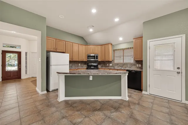 a view of a house with a yard and large tree