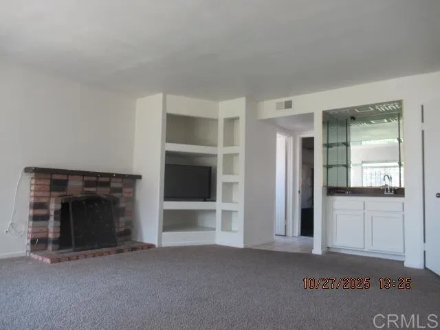 an empty room with fireplace and windows