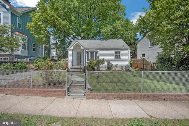 a view of a yard in front of a house with large tree