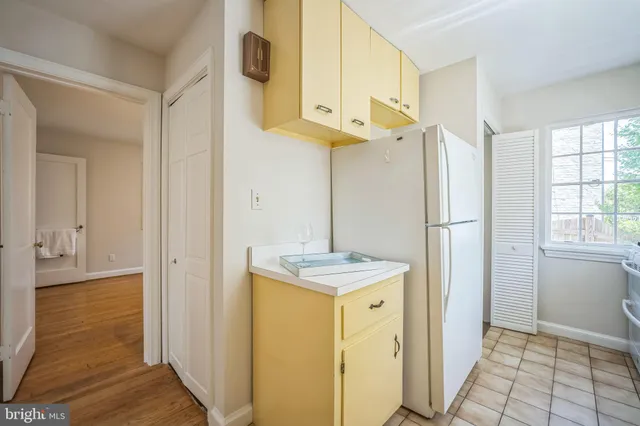 a view of a kitchen with fridge and wooden floor
