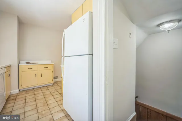 a view of a kitchen with white cabinets and wooden floor