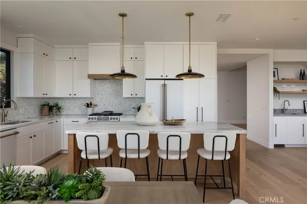 a kitchen with stainless steel appliances granite countertop a sink a refrigerator and a stove