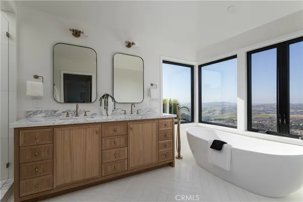 a bathroom with double vanity sinks a toilet and a mirror