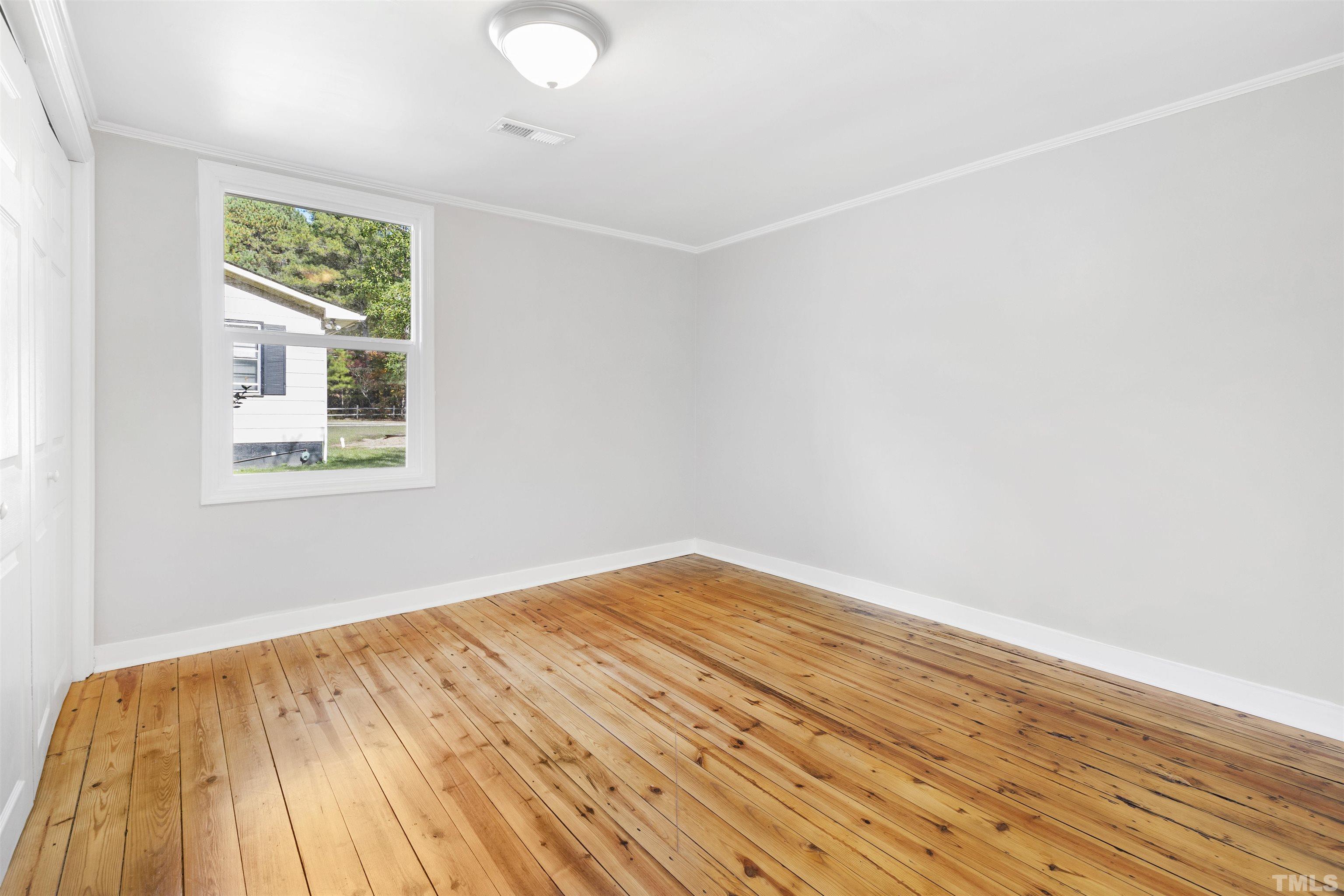 5524 Bobbitt Road Apex, NC 27539 - Photo 16 of 24 an empty room with wooden floor and windows