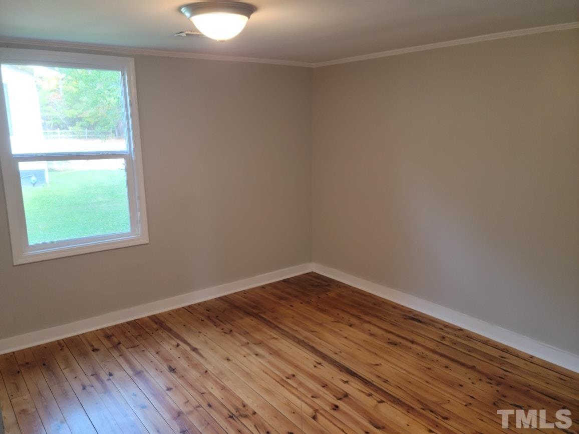 5524 Bobbitt Road Apex, NC 27539 - Photo 7 of 24 a view of an empty room with wooden floor and a window