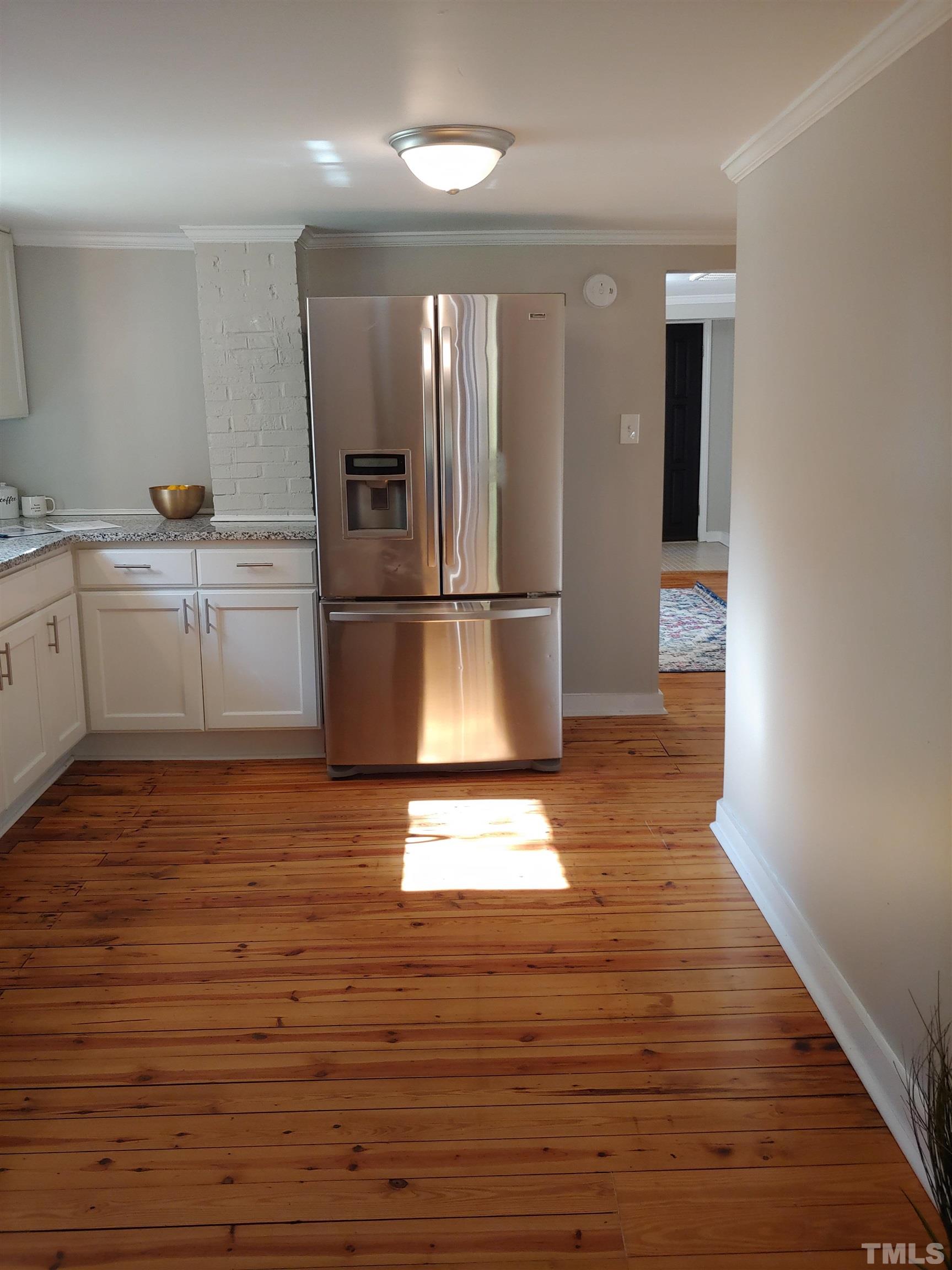 5524 Bobbitt Road Apex, NC 27539 - Photo 9 of 24 a kitchen with wooden floors and refrigerator