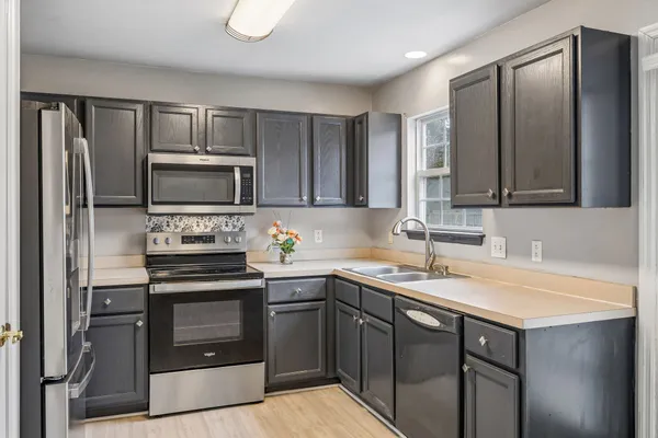 a kitchen with a sink appliances and cabinets