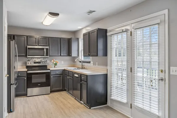 a kitchen with kitchen island granite countertop a sink stainless steel appliances and cabinets