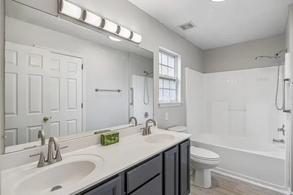 a bathroom with a sink double vanity granite toilet tub and shower