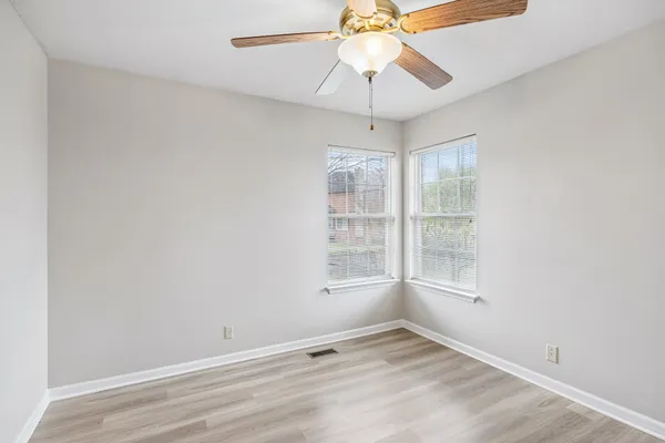 an empty room with a window and a fan