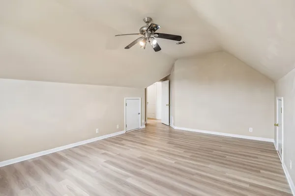 a view of a room with wooden floor and ceiling fan