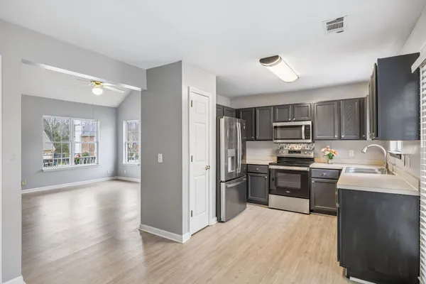 a kitchen with stainless steel appliances granite countertop a refrigerator stove top oven and sink