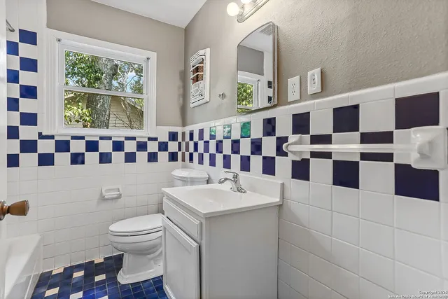 a bathroom with a sink a toilet and a shower curtain