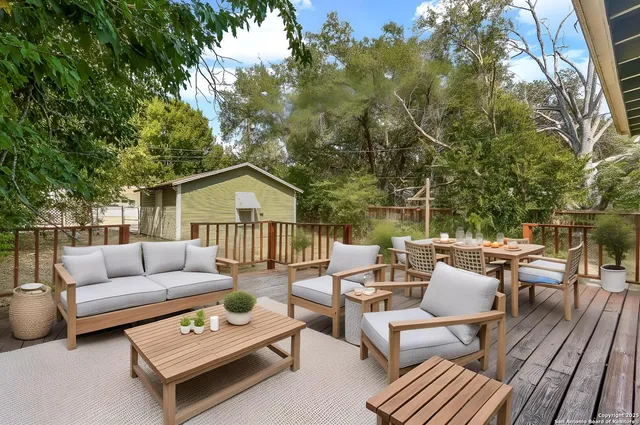 a roof deck with couches and potted plants