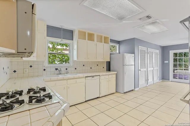 a kitchen with a sink cabinets and appliances