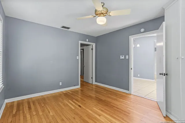 a view of empty room with wooden floor