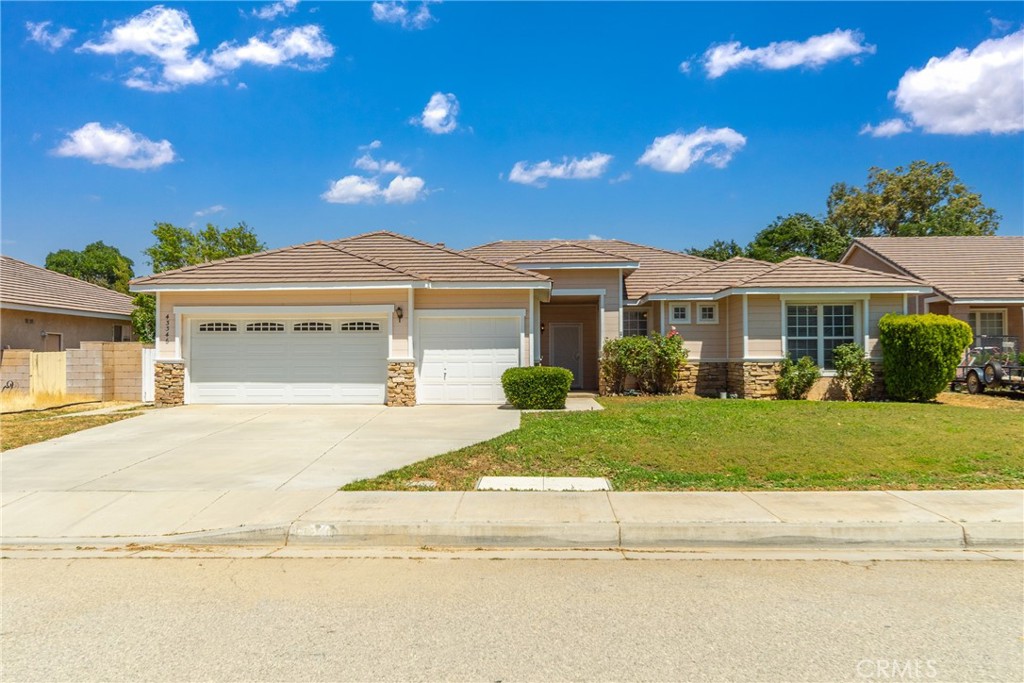 a front view of a house with a garden