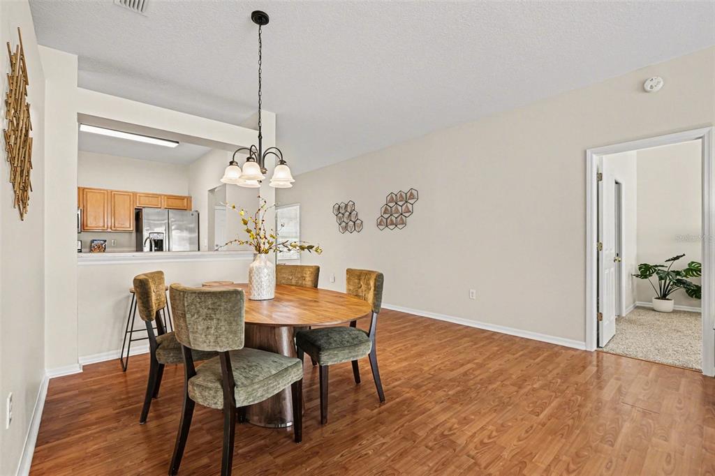 30631 Nickerson Loop Wesley Chapel, FL 33543 - Photo 12 of 33 a dining room with furniture wooden floor a rug and a chandelier