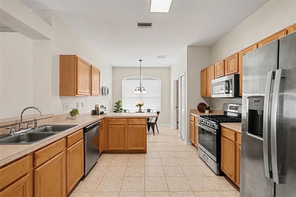 30631 Nickerson Loop Wesley Chapel, FL 33543 - Photo 17 of 33 a kitchen with stainless steel appliances granite countertop a sink stove refrigerator and cabinets