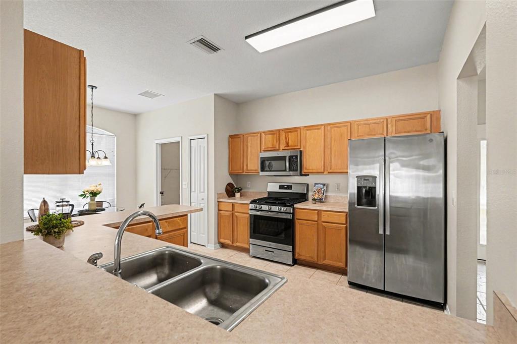 30631 Nickerson Loop Wesley Chapel, FL 33543 - Photo 21 of 33 a kitchen with a refrigerator a stove a sink and a microwave
