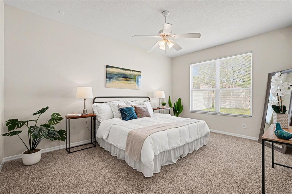 30631 Nickerson Loop Wesley Chapel, FL 33543 - Photo 22 of 33 a bedroom with bed a chandelier and a window