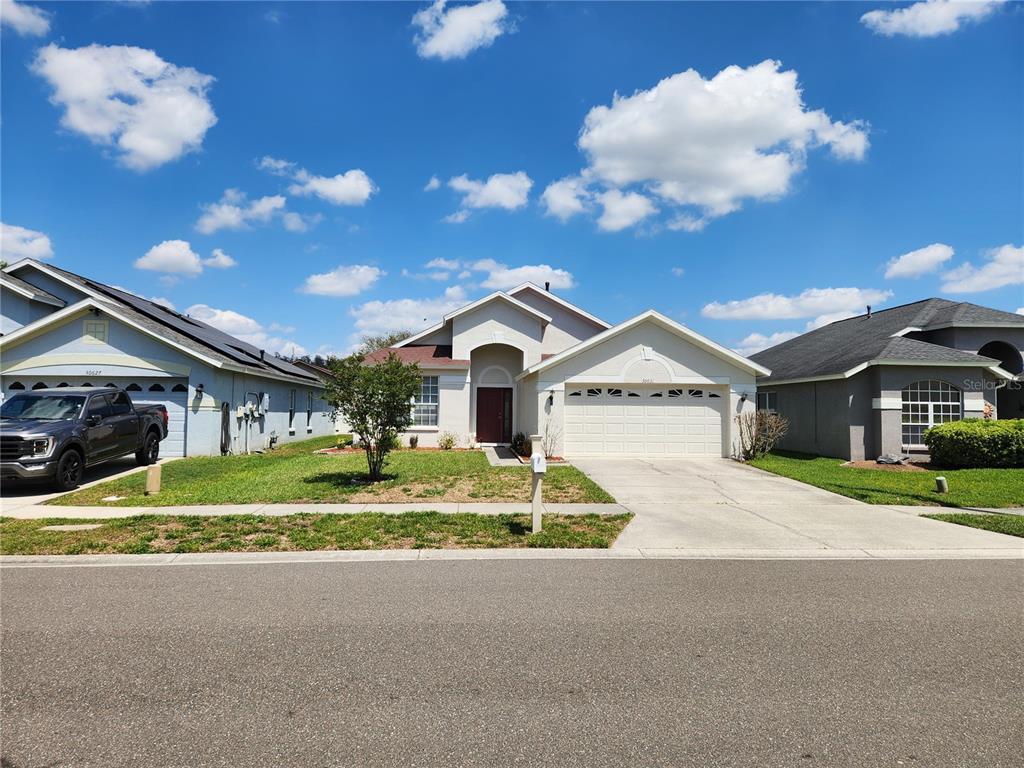 30631 Nickerson Loop Wesley Chapel, FL 33543 - Photo 3 of 33 a view of house with a yard and large tree in front of it