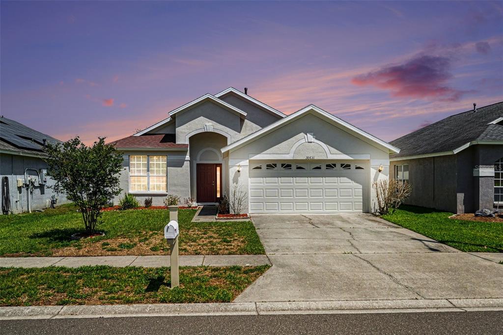 30631 Nickerson Loop Wesley Chapel, FL 33543 - Photo 4 of 33 a front view of a house with a yard and garage